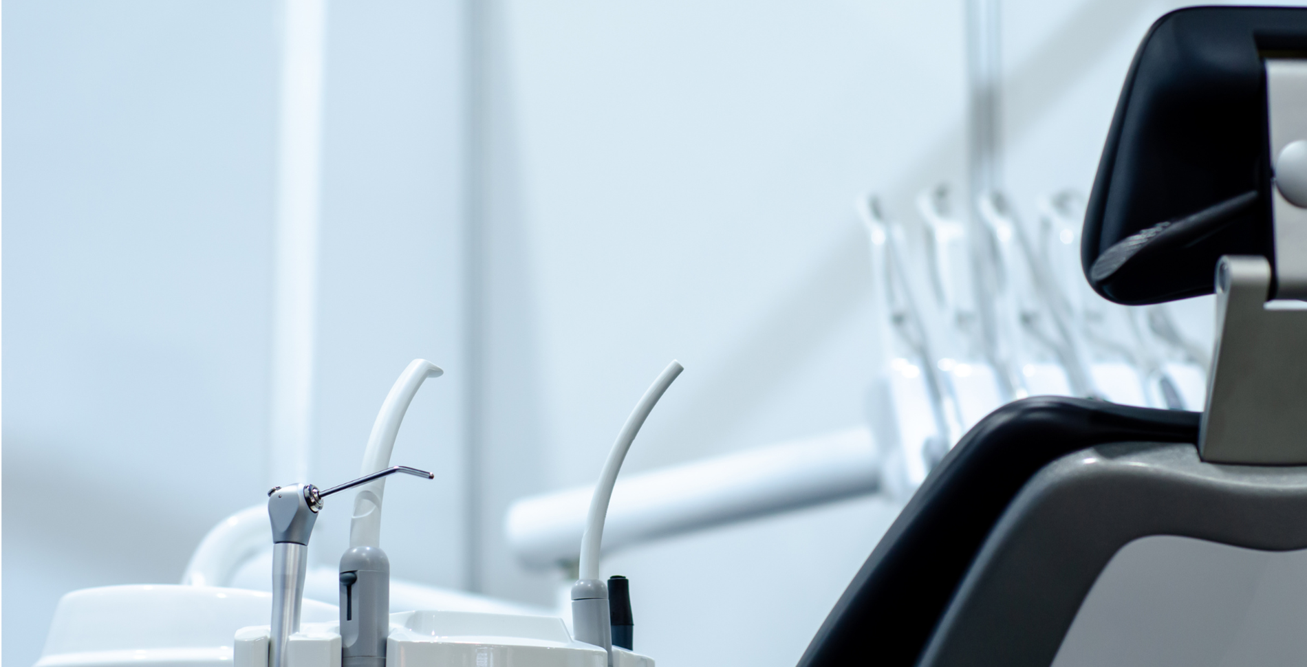 A sleek, modern dental office with a black dental chair and white dental tools on the left. The setting is clean, professional, and calming.